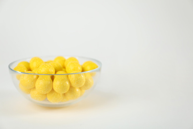 Photo of Tasty small lemon drops on white background