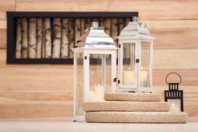 Decorative lanterns with candles on floor indoors, space for text. Interior elements