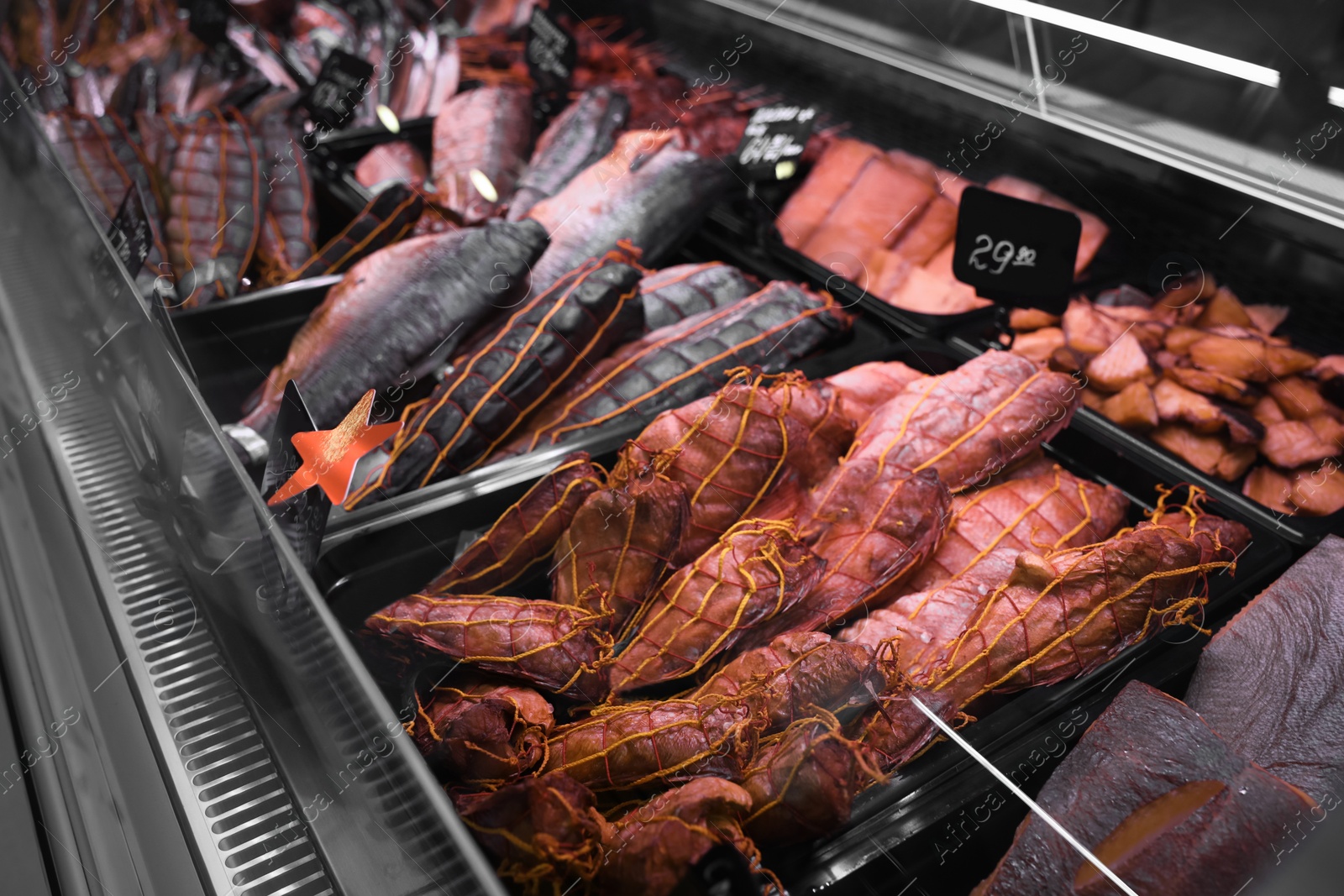 Photo of Showcase with different smoked fish in supermarket