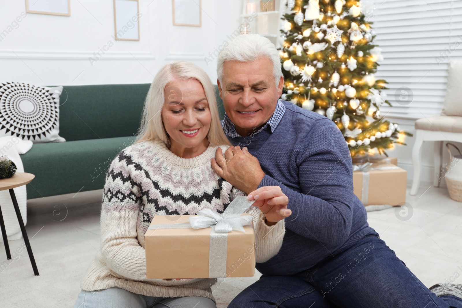 Photo of Happy mature couple with gift box at home. Christmas celebration