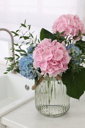 Beautiful hortensia flowers in vase on kitchen counter