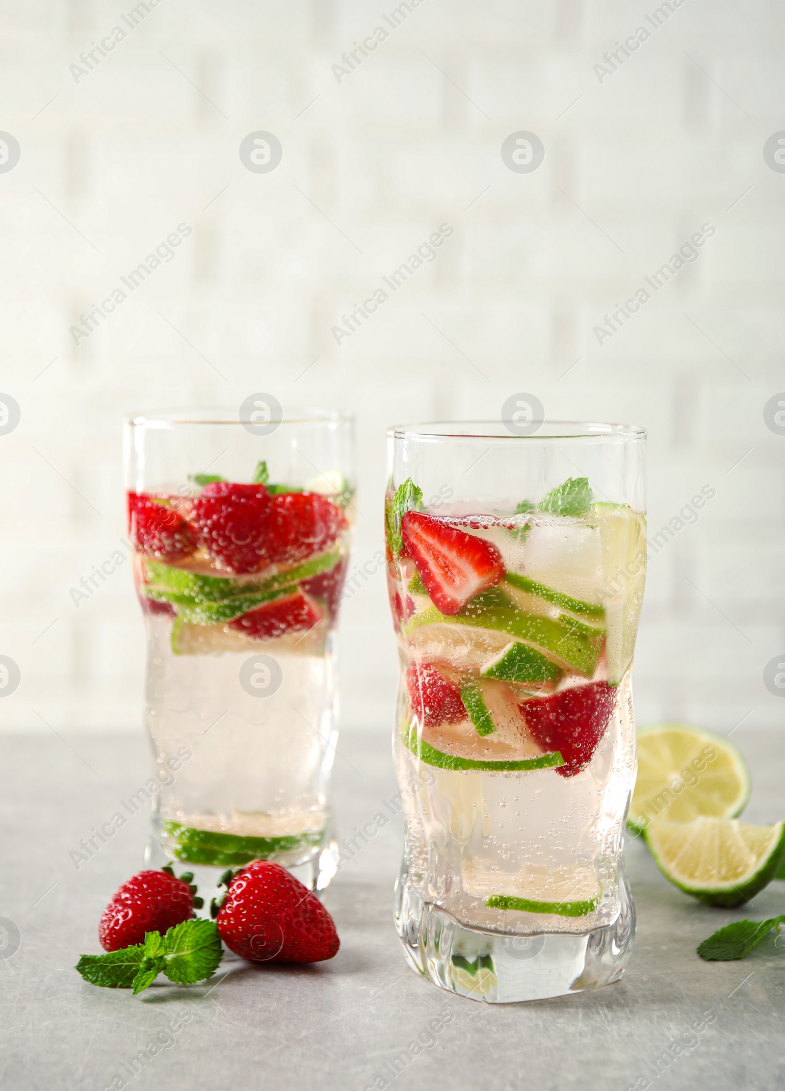 Photo of Tasty refreshing drink on light grey table. Space for text