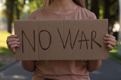 Woman holding poster with words No War in park, closeup