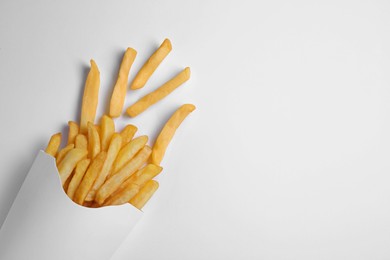 Photo of Paper cup with French fries on white table, flat lay. Space for text