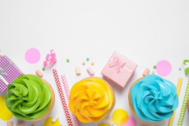 Photo of Flat lay composition with colorful birthday cupcakes on white background. Space for text