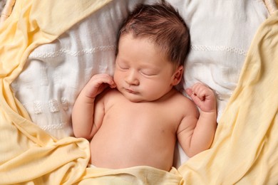 Cute newborn baby sleeping on white blanket, top view