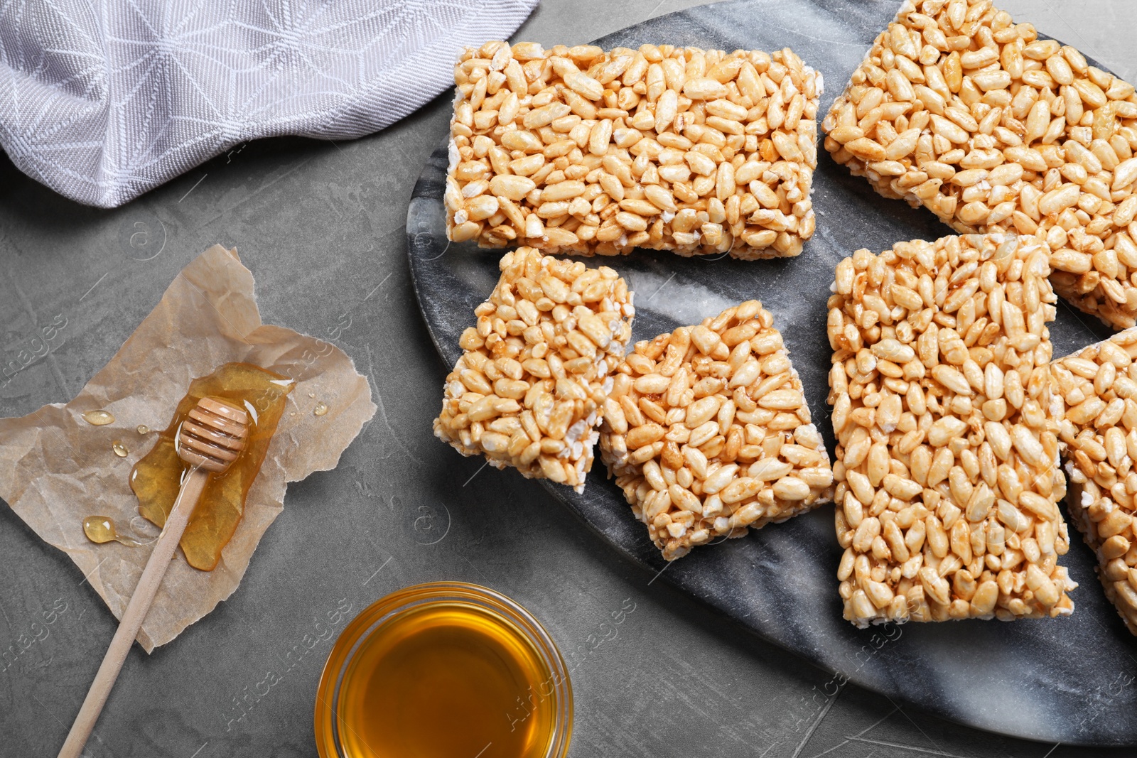 Photo of Delicious rice crispy treats on grey table, flat lay