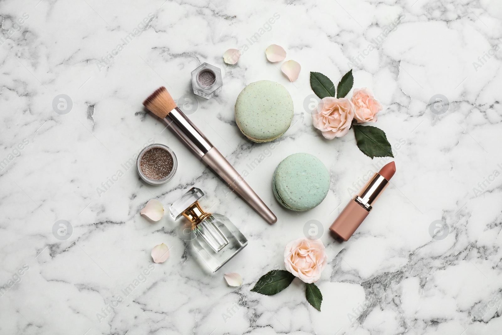 Photo of Flat lay composition with makeup products, roses and macarons on white marble background