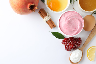 Composition with natural homemade mask, pomegranate and ingredients on white background, top view