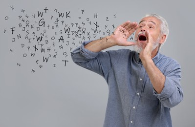 Image of Man shouting something on grey background. Letters flying out of his mouth