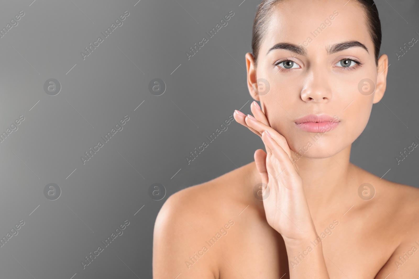 Photo of Portrait of beautiful young woman and space for text on grey background. Cosmetic surgery concept