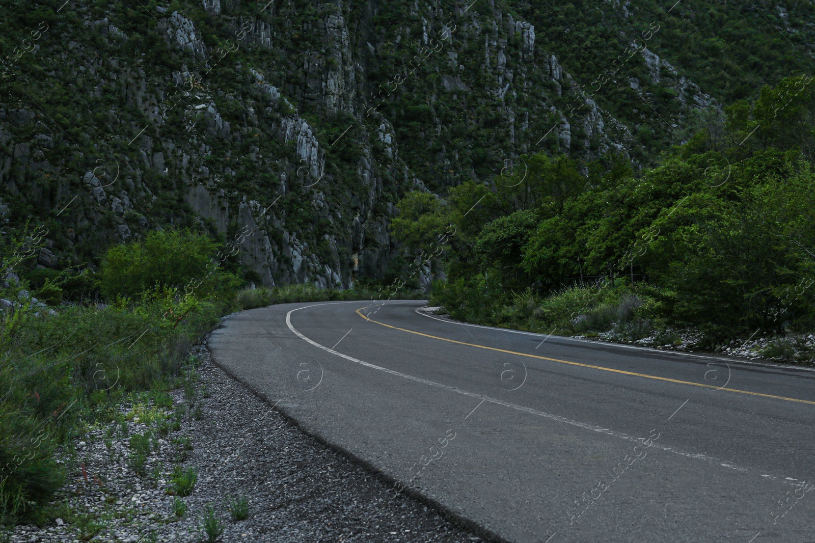 Photo of Beautiful view of empty asphalt highway near mountains outdoors. Road trip