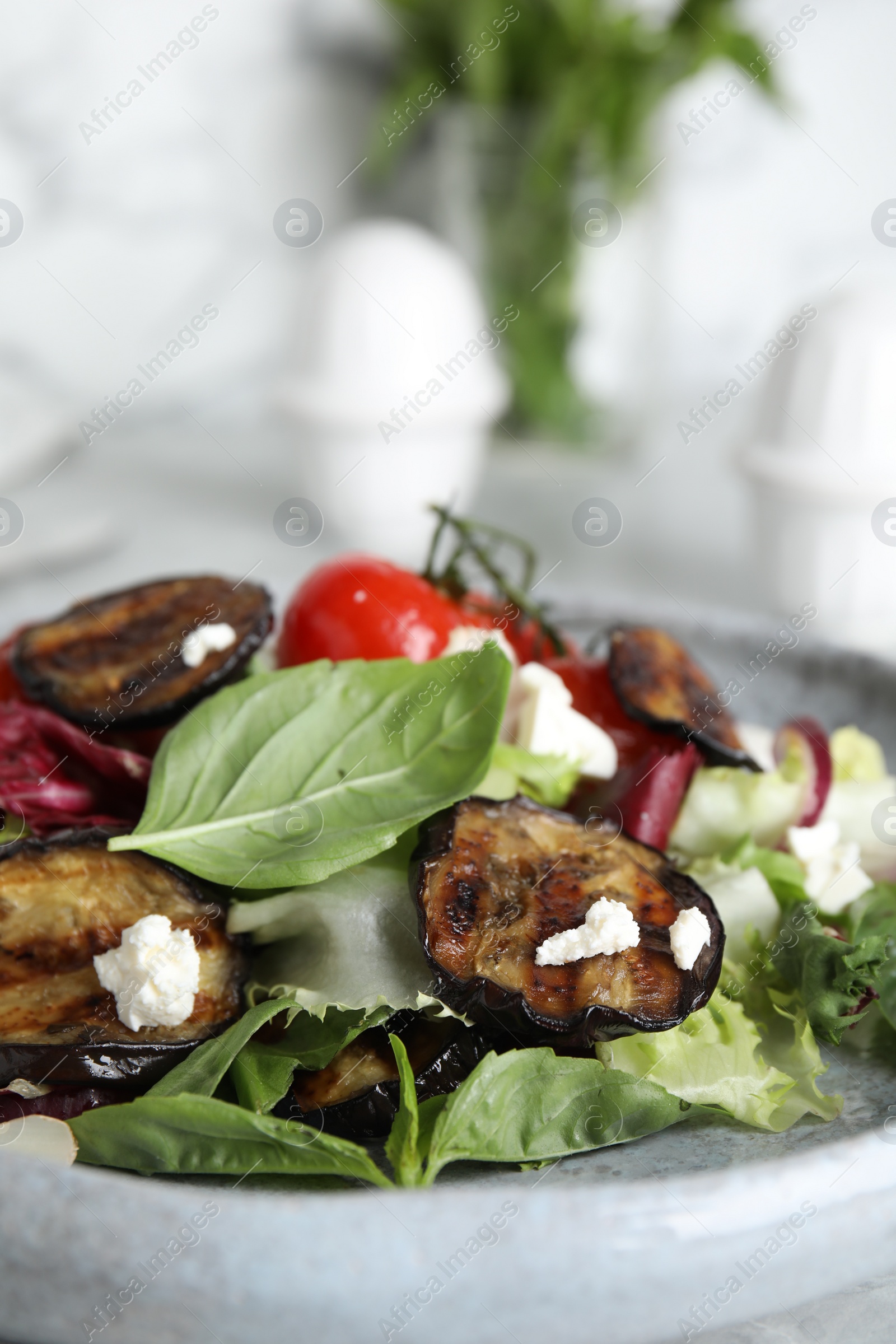 Photo of Delicious salad with roasted eggplant, basil and cheese on plate, closeup