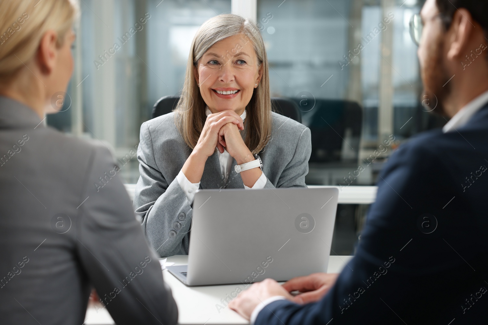 Photo of Lawyer working with clients at table in office