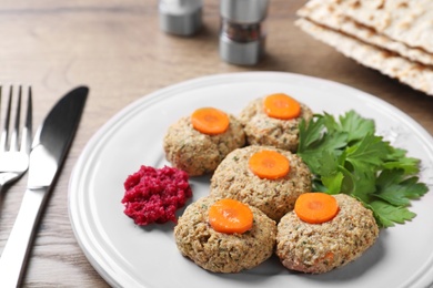 Photo of Plate of traditional Passover (Pesach) gefilte fish on wooden table, closeup