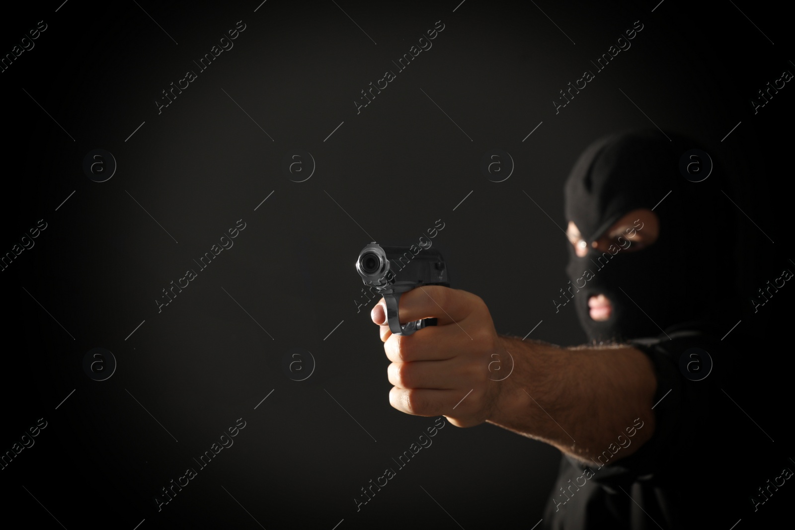 Photo of Professional killer on black background, focus on gun. Space for text