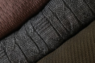 Photo of Closeup view of different warm folded sweaters as background