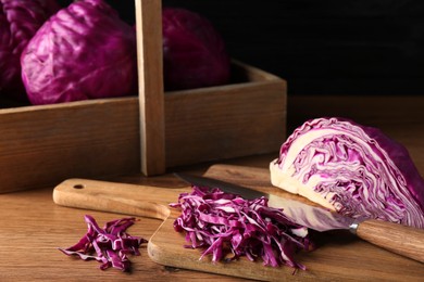 Photo of Cut fresh red cabbage on wooden table
