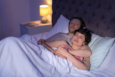 Photo of Young lovely couple sleeping in bed at home