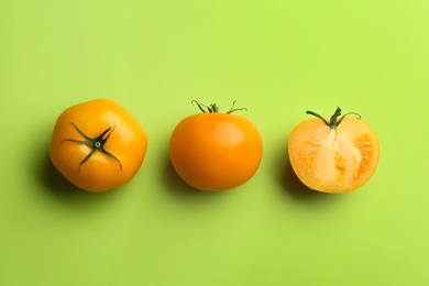 Photo of Yellow tomatoes on green background, flat lay