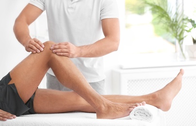 Photo of Young man receiving massage in salon, closeup