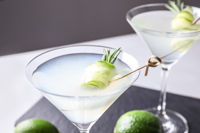 Glasses of cucumber martini on table against dark background, closeup. Space for text