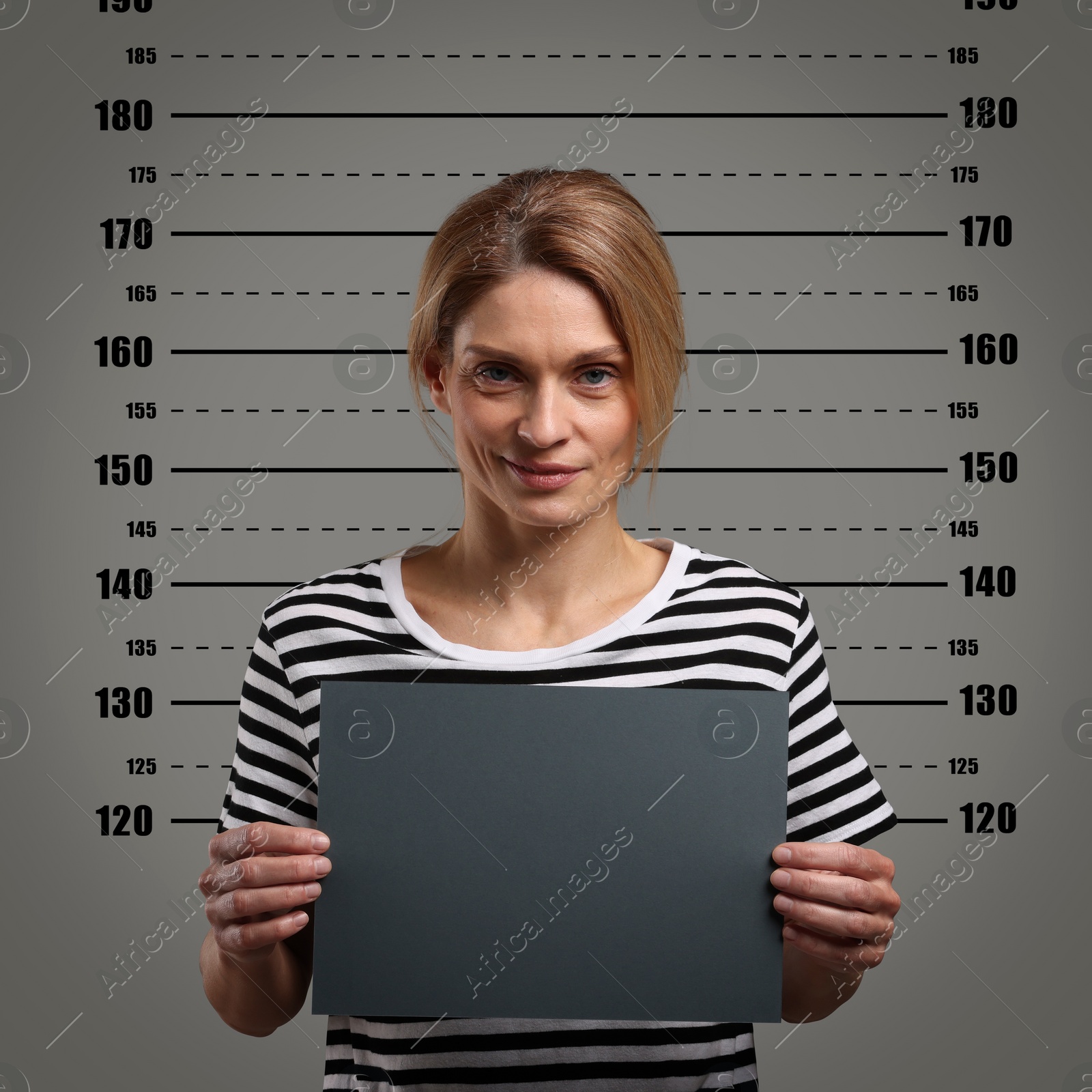 Image of Criminal mugshot. Arrested woman with blank card against height chart