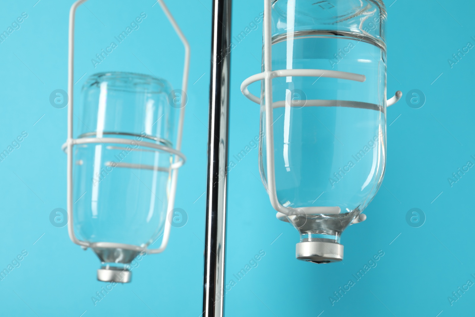 Photo of IV infusion set on pole against light blue background, closeup