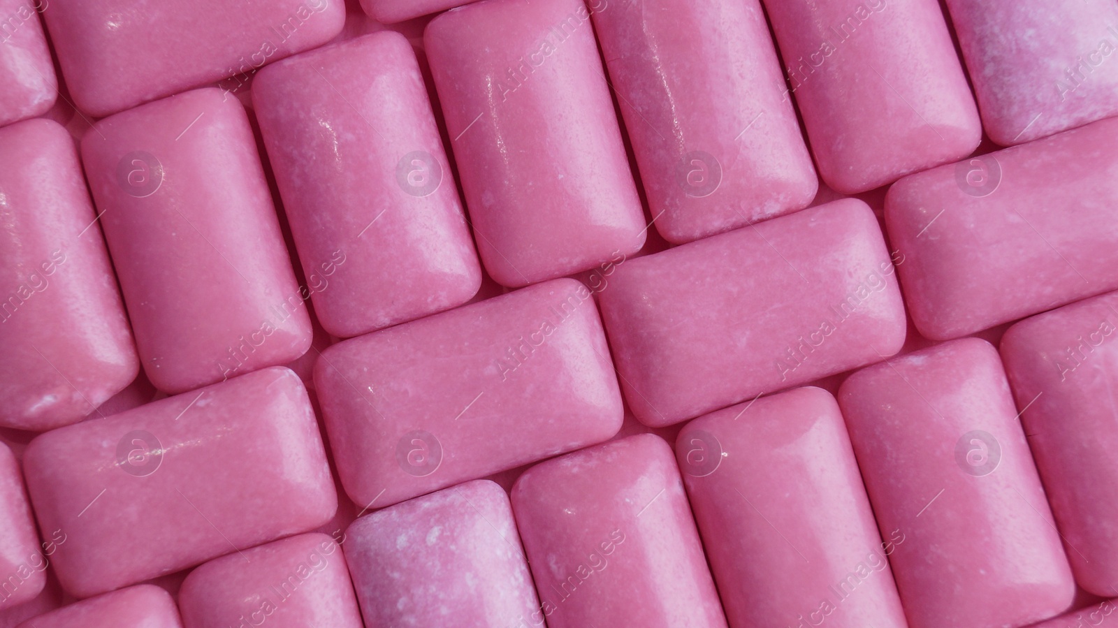 Photo of Many pink chewing gums as background, top view