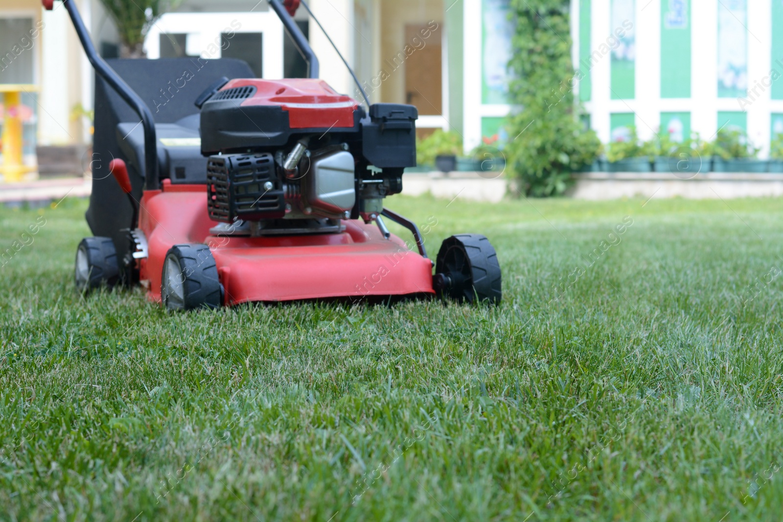 Photo of Modern garden lawn mower on green grass in park