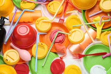 Photo of Different colorful plastic items as background, closeup