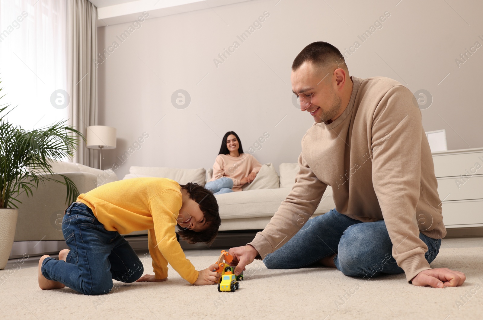 Photo of Father and his son playing together at home