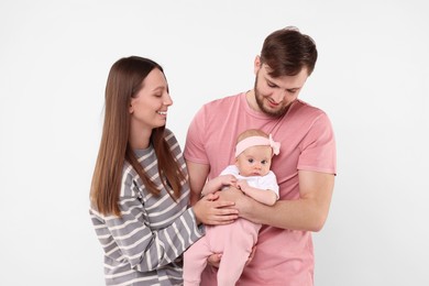 Photo of Happy family. Parents with their cute baby on light background