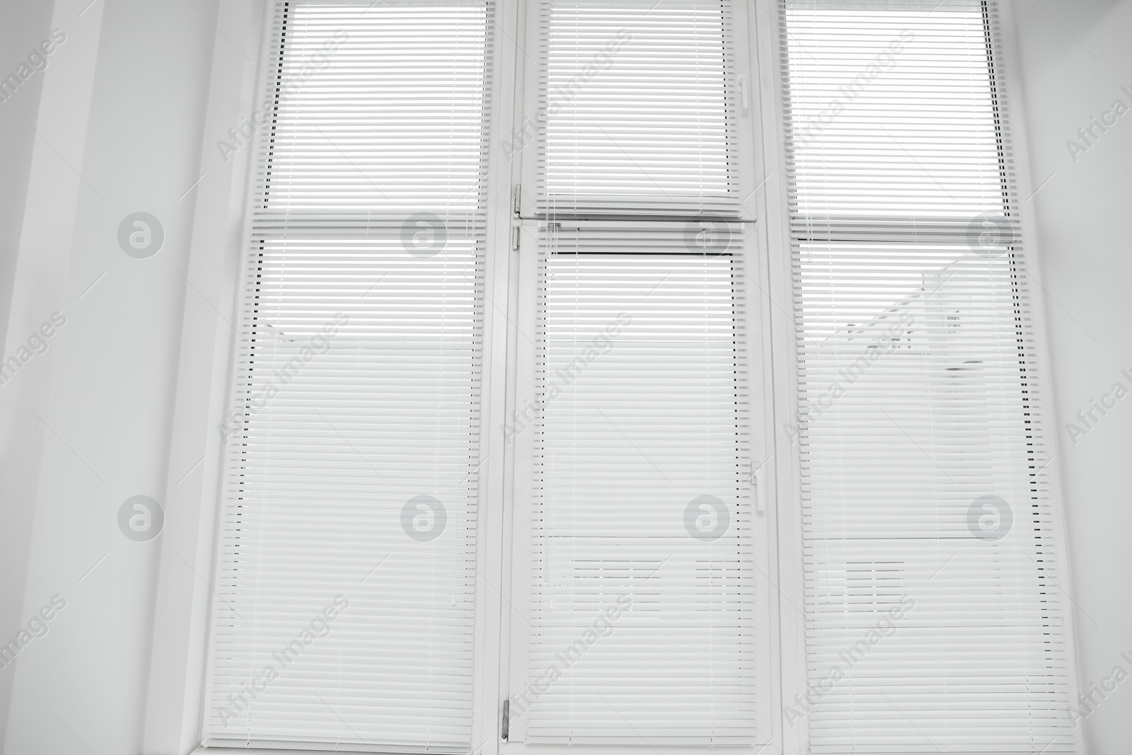 Photo of Stylish window with horizontal blinds in room