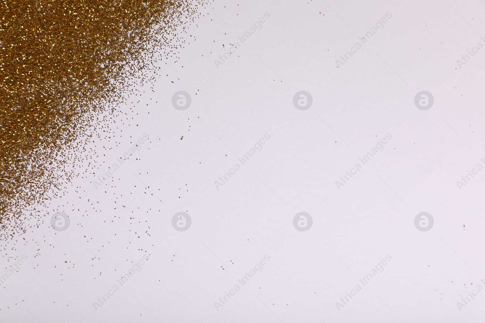 Photo of Shiny golden glitter on white background, top view