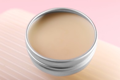 Lip balm on pink background, closeup view