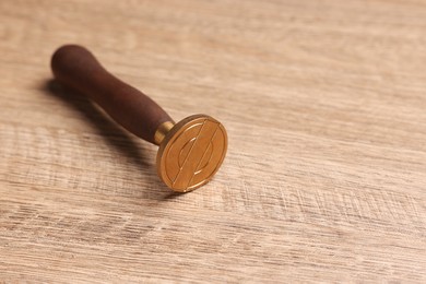 Photo of One stamp tool on wooden table, closeup. Space for text