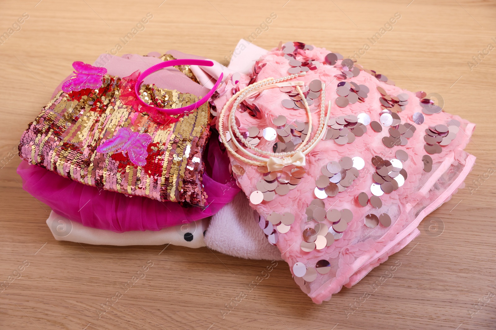 Photo of Stylish carnival costume with sequins and headbands on wooden table