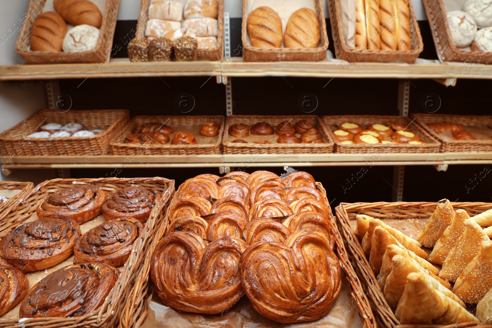 Photo of Wicker trays with different sweet buns in bakery