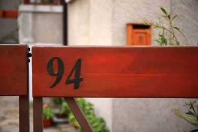 Photo of Number 94 on wooden fence outdoors, space for text
