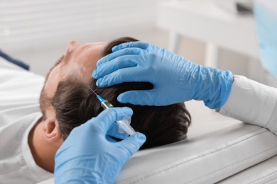 Trichologist giving injection to patient in clinic, closeup