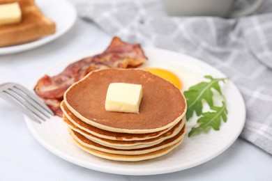 Photo of Tasty pancakes served with fried egg and bacon on white table