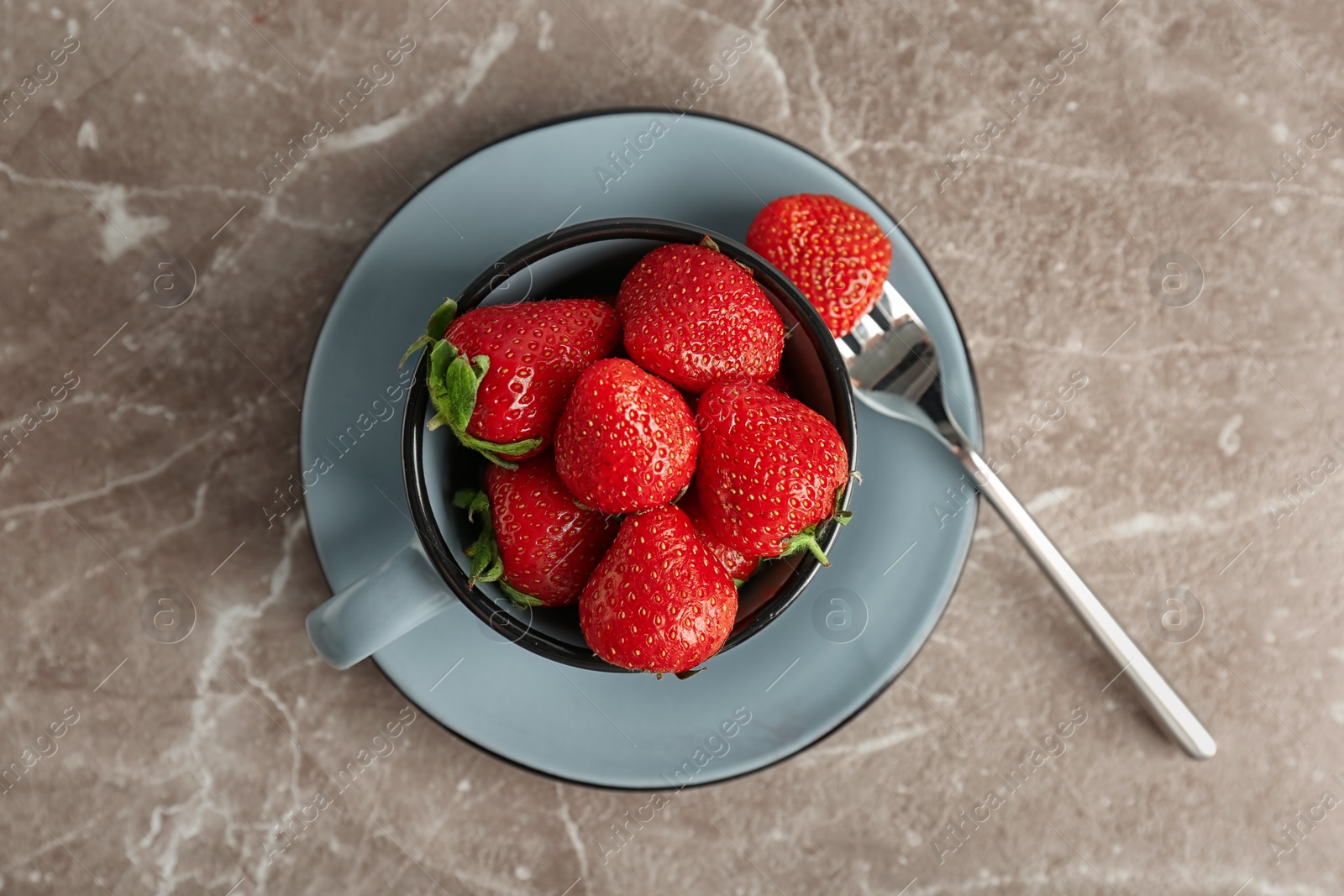 Photo of Cup with ripe red strawberries on table, top view