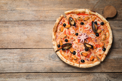 Tasty pizza with seafood on wooden table, top view. Space for text