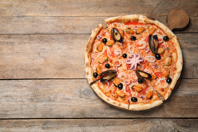 Photo of Tasty pizza with seafood on wooden table, top view. Space for text