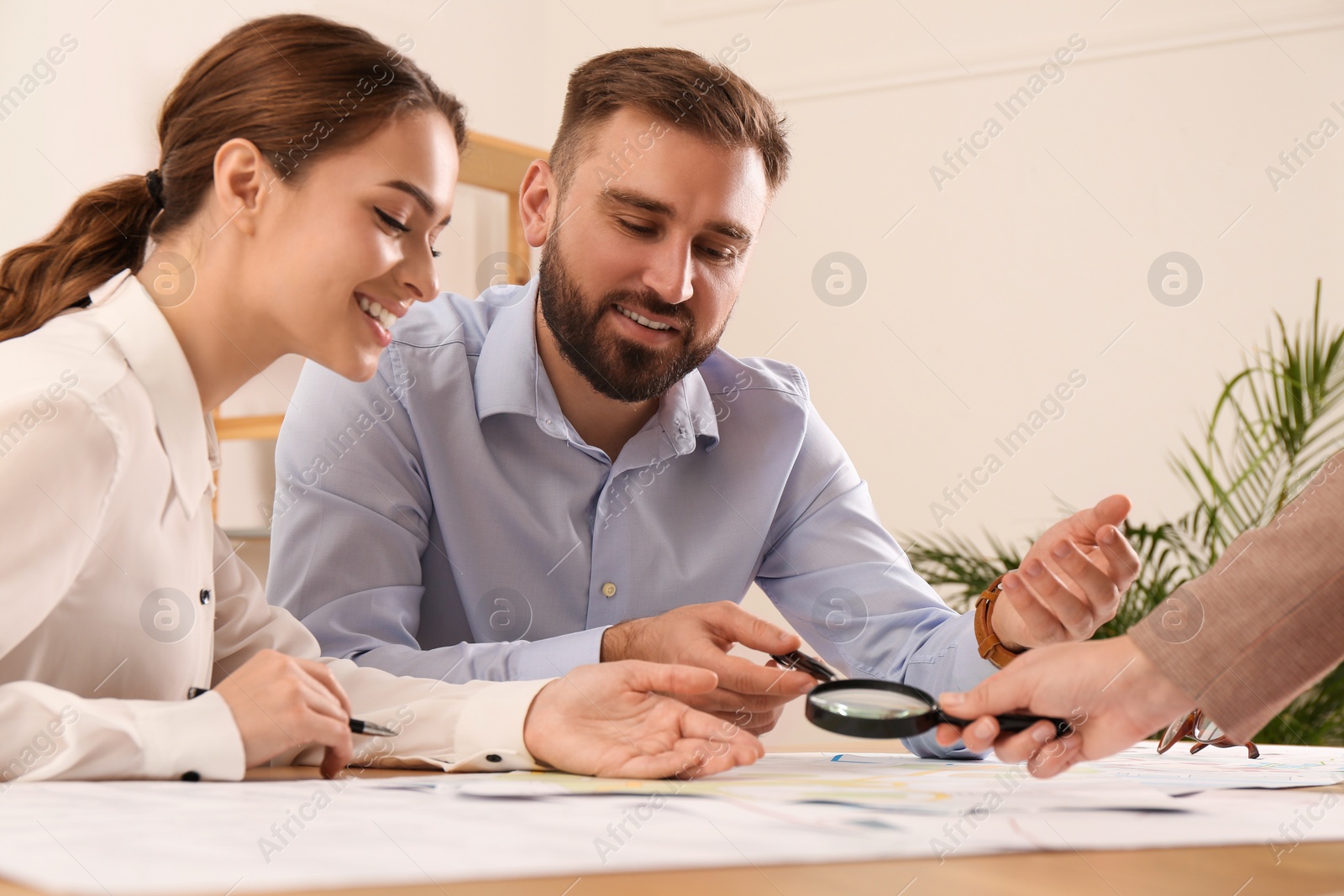 Photo of Professional cartographers working with cadastral map at table in office