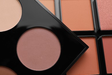 Photo of Colorful contouring palettes as background, closeup. Professional cosmetic product