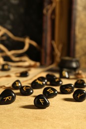 Photo of Wooden board with many black rune stones on table