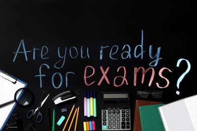 Black chalkboard with phrase Are You Ready For Exams and different stationery, flat lay
