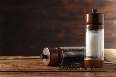 Photo of Salt and pepper shakers on wooden table, space for text